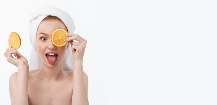 Great food for a healthy lifestyle. Beautiful young shirtless woman holding piece of orange standing against white background