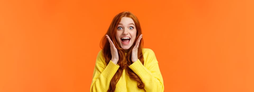 Excitement, emotions and holidays concept. Waist-up shot cheerful impressed and excited redhead woman screaming from thrill and joy, hold hands near face, open mouth and glance amazed.