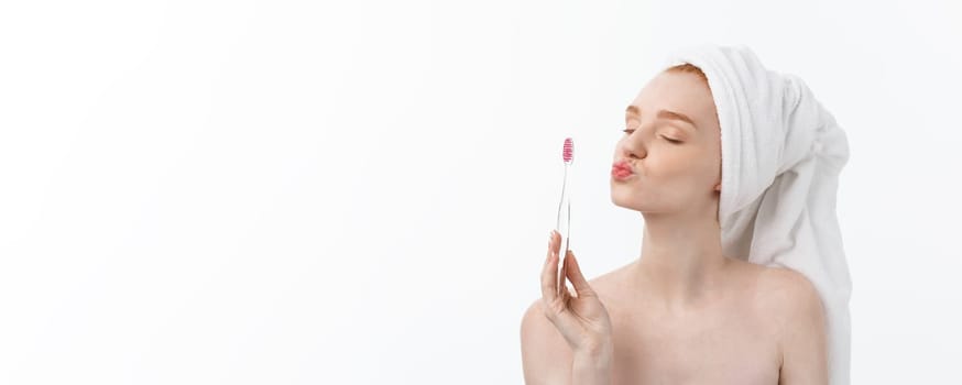 Portrait of young woman with toothbrush on grey background