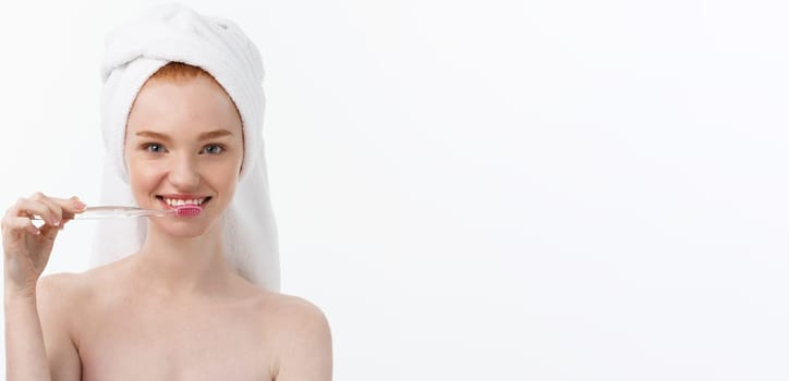 Portrait of young woman with toothbrush on grey background