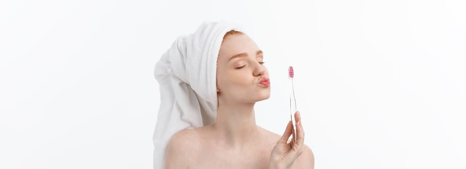 Portrait of young woman with toothbrush on grey background