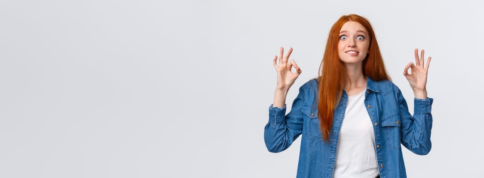 Excited and happy fascinated redhead woman looking pleased and astonished, visit awesome favorite movie, showing okay gesture, review amazing party, smiling and staring thrilled.