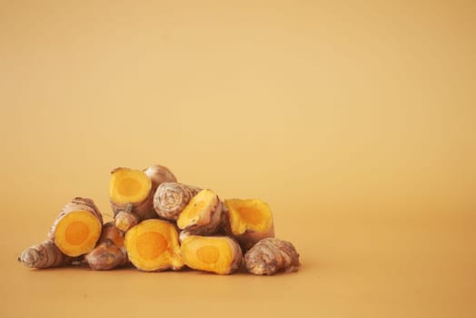 turmeric roots on a orange color background with copy space ,