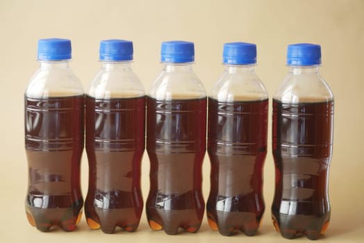 plastic bottles of soft drink on table .