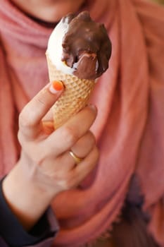 Female holds in her hand a cone with ice cream