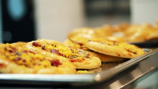 close-up, showcase with mini pizza, yeast dough baking in modern canteen, cafeteria, Self service restaurant of public catering, mess hall. High quality photo