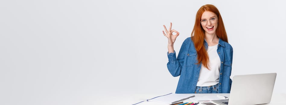 No problem, everything excellent. Confident creative redhead woman have plan, prepare design project, working with team on drawing, standing near table with laptop, colored pencils, show ok.