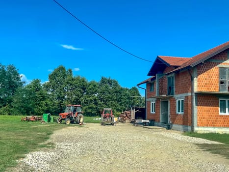 Ljevcanica, Bosnia and Herzegovina, August 23, 2023: Unfinished house with tractors near the village of Ljevcanica in the Banja Luka region, Republika Srpska, Bosnia and Herzegovina