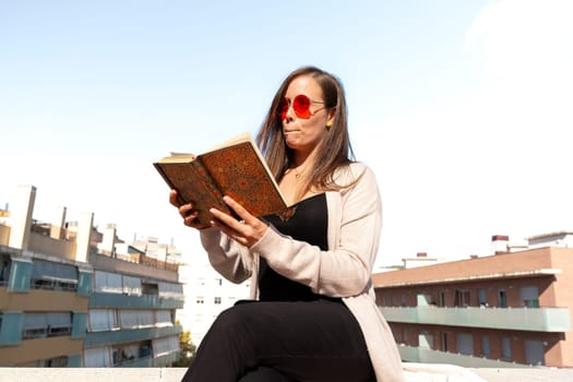 A concentrated Caucasian woman reads a book.