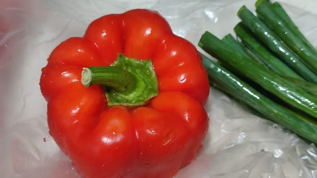 red sweet bell pepper fresh whole, green onion,food vegetables cooking vegetarian nature. High quality photo