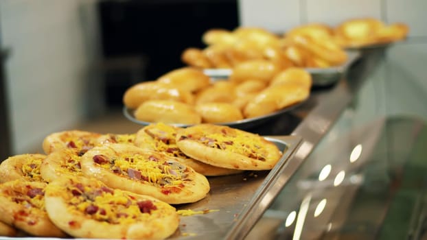 close-up, showcase with mini pizza, yeast dough baking in modern canteen, cafeteria, Self service restaurant of public catering, mess hall. High quality photo