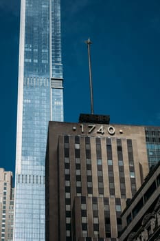 A striking view of New York's cityscape featuring both a modern glass skyscraper and historic architecture. The blend of old and new highlights the dynamic urban environment of one of the world's most iconic cities.