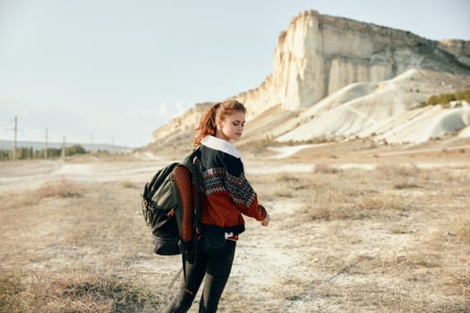 adventurous woman standing in desert wilderness with majestic mountains in the distance