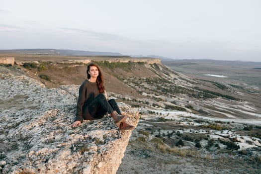 Solitude in the desert woman contemplating vast arid landscape from rocky outcrop