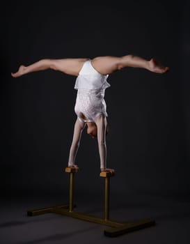 Image of charming gymnast doing handstand on circus stands