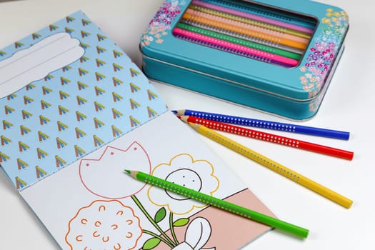 Colored pencils for drawing various colors and coloring book for children. Children's creativity concept.
