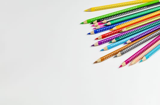 Colored pencils for drawing various colors on a white background. High quality photo
