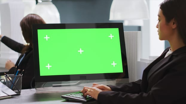 Cad designer using PC with greenscreen at workstation area, examining monitor with blank copyspace design in startup company. Engineer uses isolated chromakey display on computer.