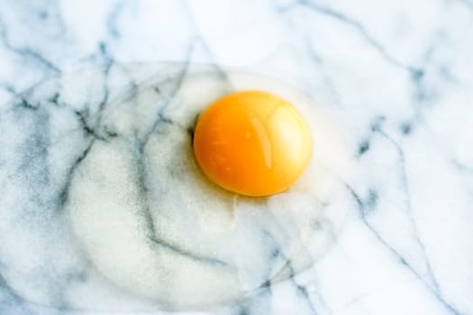 egg yolk on marble - recipe ingredients and homemade cooking styled concept