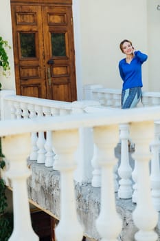 woman in blue clothes stands at the door of the front door