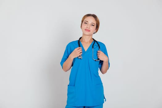 a female doctor in blue suit with stethoscope in hospital office