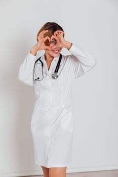 a woman doctor in white coat with phonendoscope stethoscope in hospital shows heart