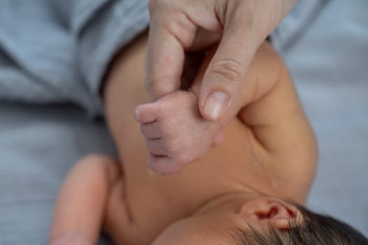 A newborn boy holds his mother's finger. Close-up of hands