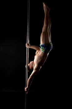 Male pole dance. Photo of strong guy posing at camera