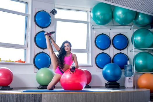 Image of beautiful sporty woman trains in modern gym