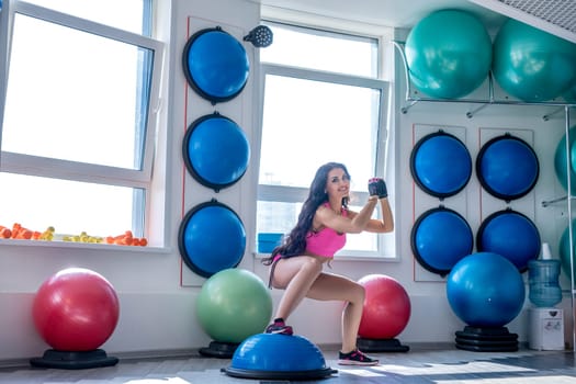 Image of smiling pretty woman doing squats at gym