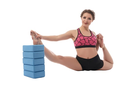 Sport. Image of lovely brunette stretching with bricks