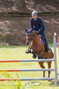 19 may 2024, Mafra, Portugal - competition in military academy - man in a uniform is riding a horse over a fence