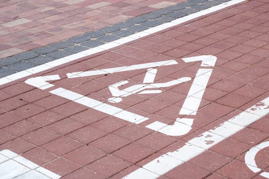 A handicapped sign is painted on the surface of a brick road, a key feature of the infrastructure showcasing accessibility and safety for pedestrians and motorists alike