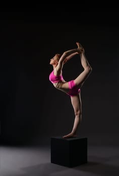 Red-haired ballet dancer doing vertical gymnastic split