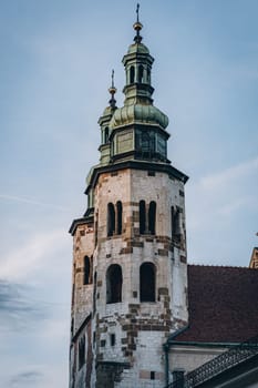 Vintage church towers with cross on green domes and arched windows in Krakow, Poland