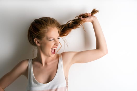 Image of cute girl screaming and pulling herself pigtail