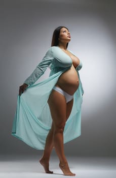 Photo of beautiful pregnant woman posing in negligee