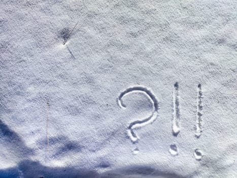 A large question mark is etched into the fresh snow, creating a stark contrast against the white surface on a serene winter morning.