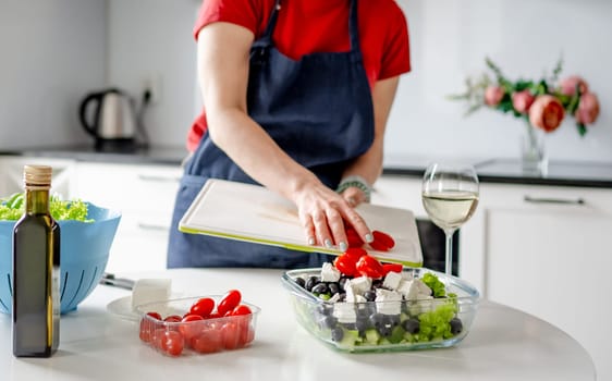 Girl Pours Chopped Cherry Tomatoes Into Bowl For Greek Salad Preparation