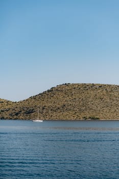 Untouched beach of Dugi Otok island in hot weather, modern boat saoling in Adriatic Sea waters, Croatia