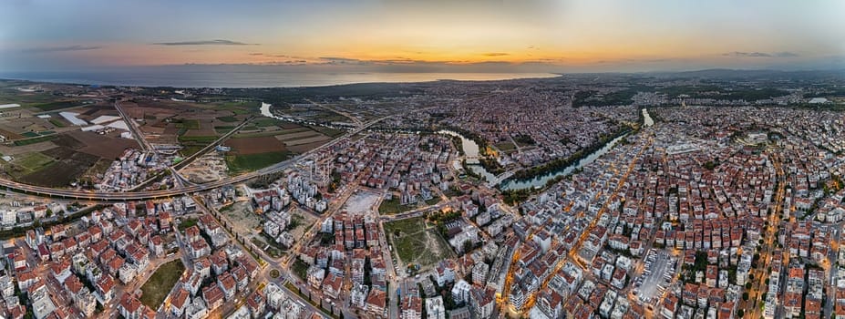 Aerial view of the city of Manavgat, the Manavgat River, the Mediterranean Sea, in the evening at sunset. Antalya region, Turkey.