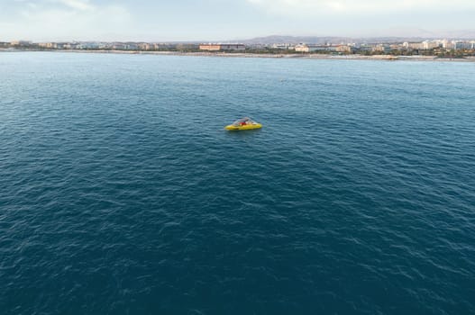 Aerial view of Evrenseki Beach with the single motorboat on the crystal clear sea in the evening. Turkey.