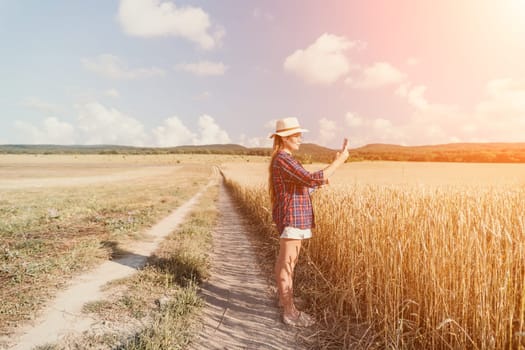 Woman farmer walks through a wheat field at sunset, touching green ears of wheat with his hands. Hand farmer is touching ears of wheat on field in sun, inspecting her harvest. Agricultural business.