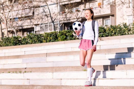 smiling caucasian woman walking at park with a soccer ball in hand, concept of sport and active lifestyle, copy space for text