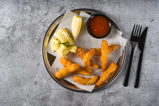 Deep fried shrimp tempura with potato salad on a metal plate