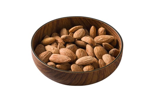 Roasted salted almonds in wooden bowl on isolated white background