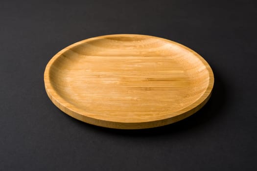 Wooden plate on dark gray background. handmade kitchen utensils