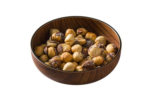 Roasted salted hazelnuts in wooden bowl on isolated white background