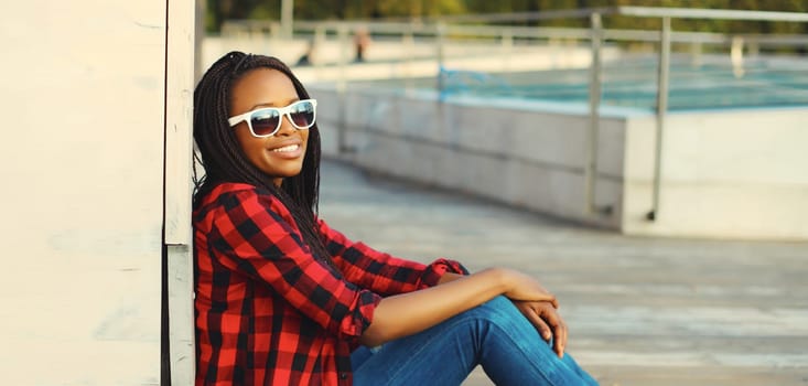 Portrait of stylish young african woman with dreadlocks posing wearing casual in the city