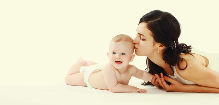 happy young mother playing with baby lying on the floor at home